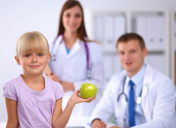 Conceito de criança e medicina - médico feminino dando uma maçã a uma menina — Fotografia de Stock