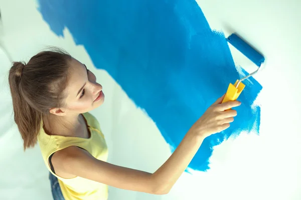 Beautiful young woman doing wall painting Stock Image