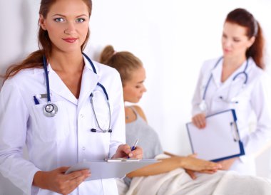 Hastanede üniformalı, gülümseyen bir kadın doktor.