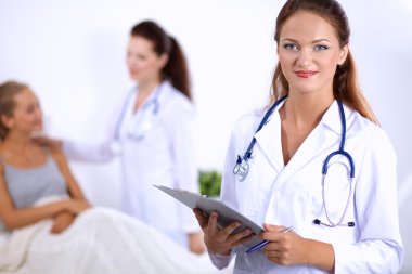 Hastanede üniformalı, gülümseyen bir kadın doktor.