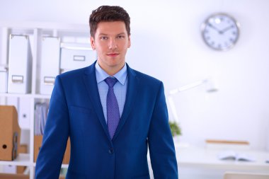 Ofiste masasının karşısında duran bir iş adamı ya da yönetici. 