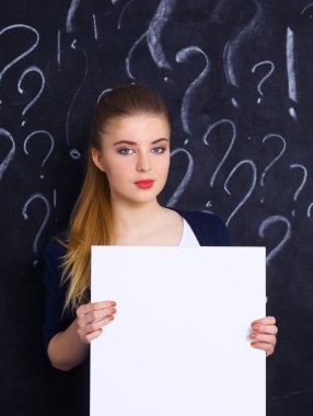 soru işareti gri arka plan üzerinde boş bir holding ile genç kız