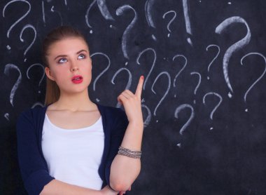 soru işareti gri bir arka plan üzerinde bulunan genç kız