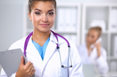 Hastanede üniformalı, gülümseyen bir kadın doktor.