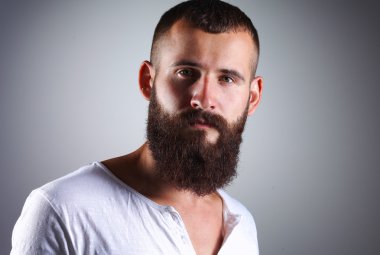 ayakta, gri arka plan üzerinde izole yakışıklı sakallı adam portresi