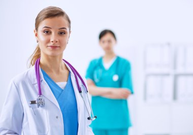 Kadın doktor hastanede steteskopla dikiliyor.