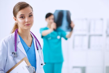 Kadın doktor hastanede dosyayla bekliyor.