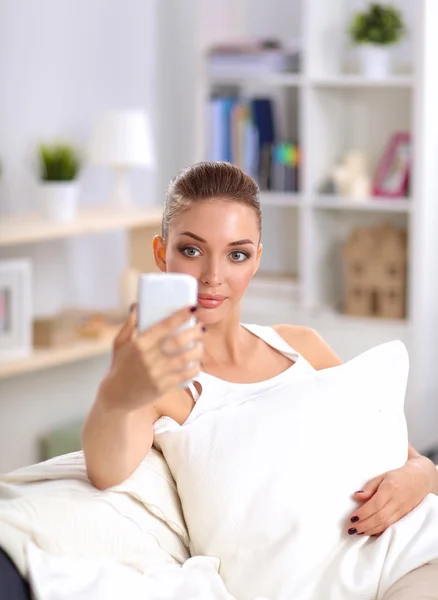 Glückliche Brünette macht ein Foto von sich mit ihrem Handy im Schlafzimmer — Stockfoto