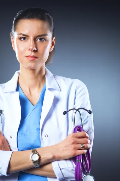 Porträtt av ung kvinnlig läkare som håller ett stetoskop, isolerad på svart bakgrund — Stockfoto