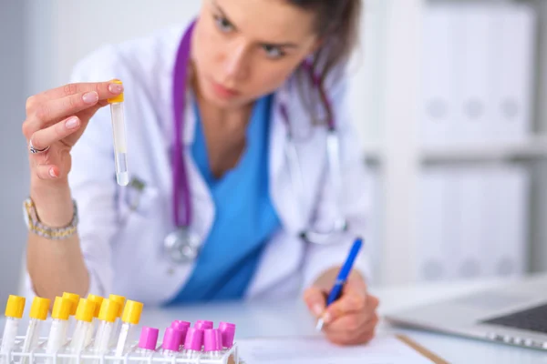 Женщина-исследователь окружена медицинскими ампулами и колбами, изолированными на белом фоне — стоковое фото