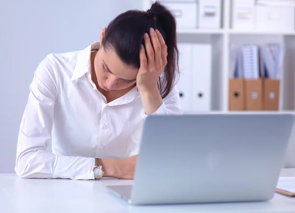 Stressad affärskvinna sitter vid skrivbordet på kontoret — Stockfoto