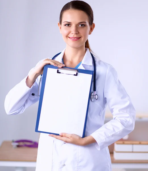 Médico sonriente con una carpeta en uniforme de pie — Foto de Stock