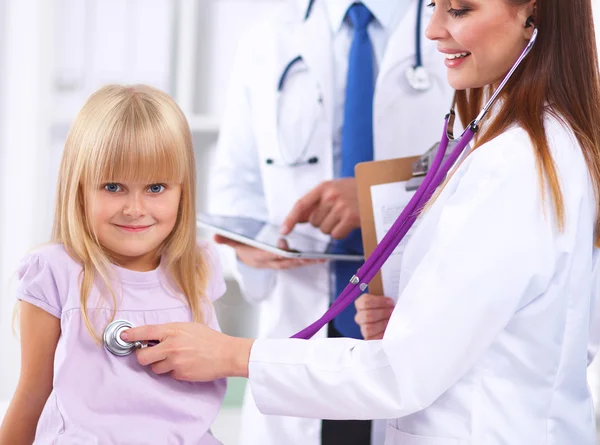 Female doctor examining child with stethoscope at surgery — Stock Photo, Image