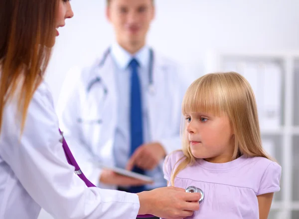 Female doctor examining child with stethoscope at surgery — Stock Photo, Image