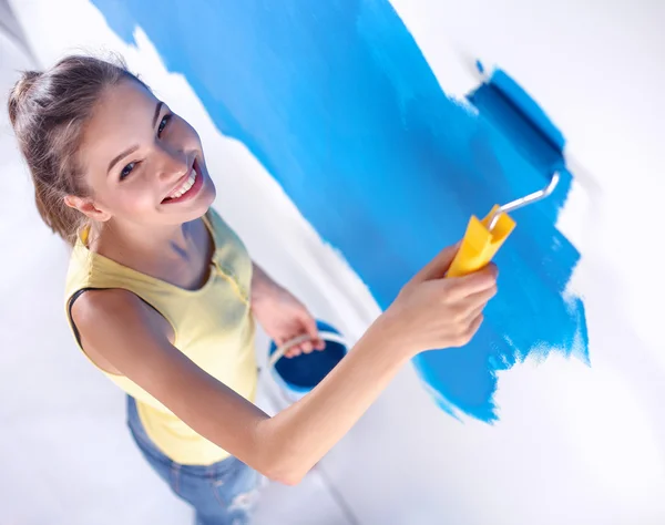 Szczęśliwa piękna młoda kobieta maluje ściany, — Zdjęcie stockowe