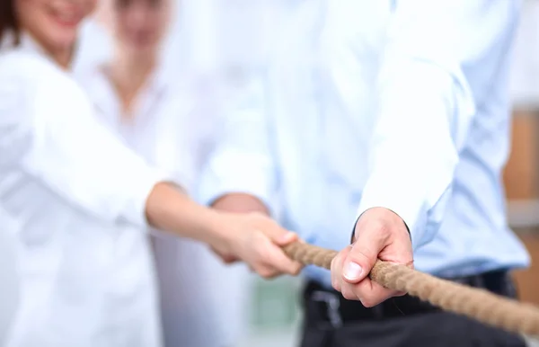 Konzeptbild eines Geschäftsteams, das ein Seil als Element der Teamarbeit im Vordergrund verwendet — Stockfoto