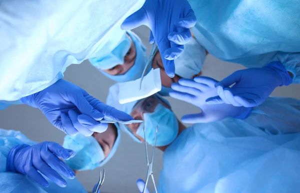 Cirurgiões segurando instrumentos médicos nas mãos e olhando para o paciente — Fotografia de Stock