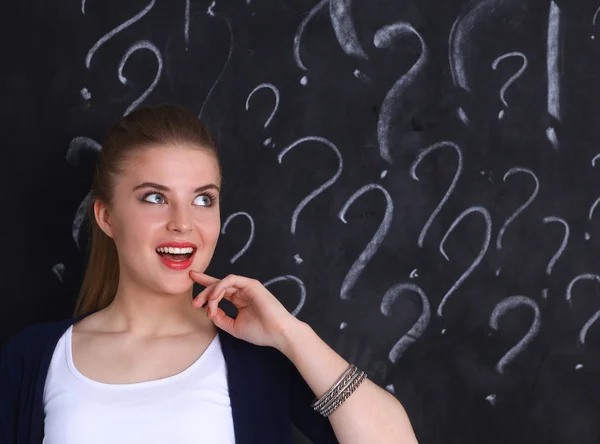 Young girl with question mark on a gray background — Stock Photo, Image