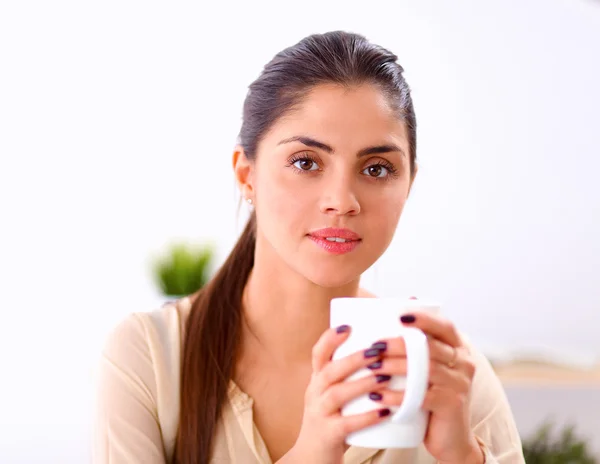 Schöne Geschäftsfrau genießt Kaffee im hellen Büro — Stockfoto