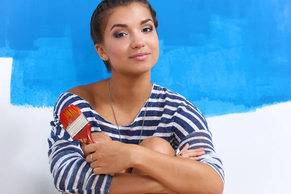 Portrait of female painter sitting on floor near wall after painting. — Stock Photo, Image