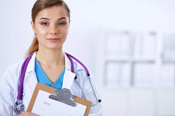 Woman doctor standing with folder at hospital — Stock Photo, Image