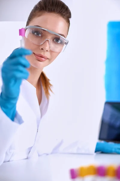 Woman researcher is surrounded by medical vials and flasks, isolated on white background — Stock Photo, Image