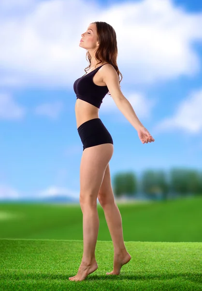 Young fitness girl standing on green grass — Stock Photo, Image