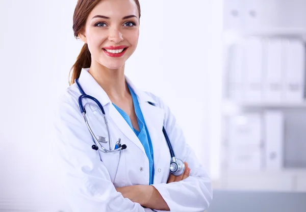 Retrato de una joven doctora con una bata blanca de pie en el hospital Imagen de archivo