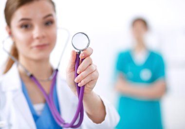 Steteskoplu kadın doktor dinliyor.