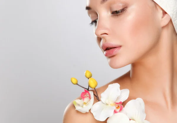 Woman in towel with orchid flowers — Stock Photo, Image