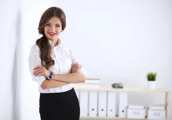Aantrekkelijke zakenvrouw in de buurt van muur in kantoor — Stockfoto