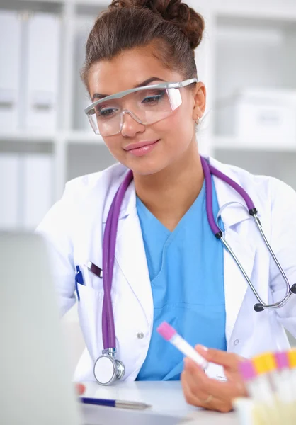 Kvinnlig forskare är omgiven av medicinska flaskor och kolvar, isolerade på vit bakgrund — Stockfoto