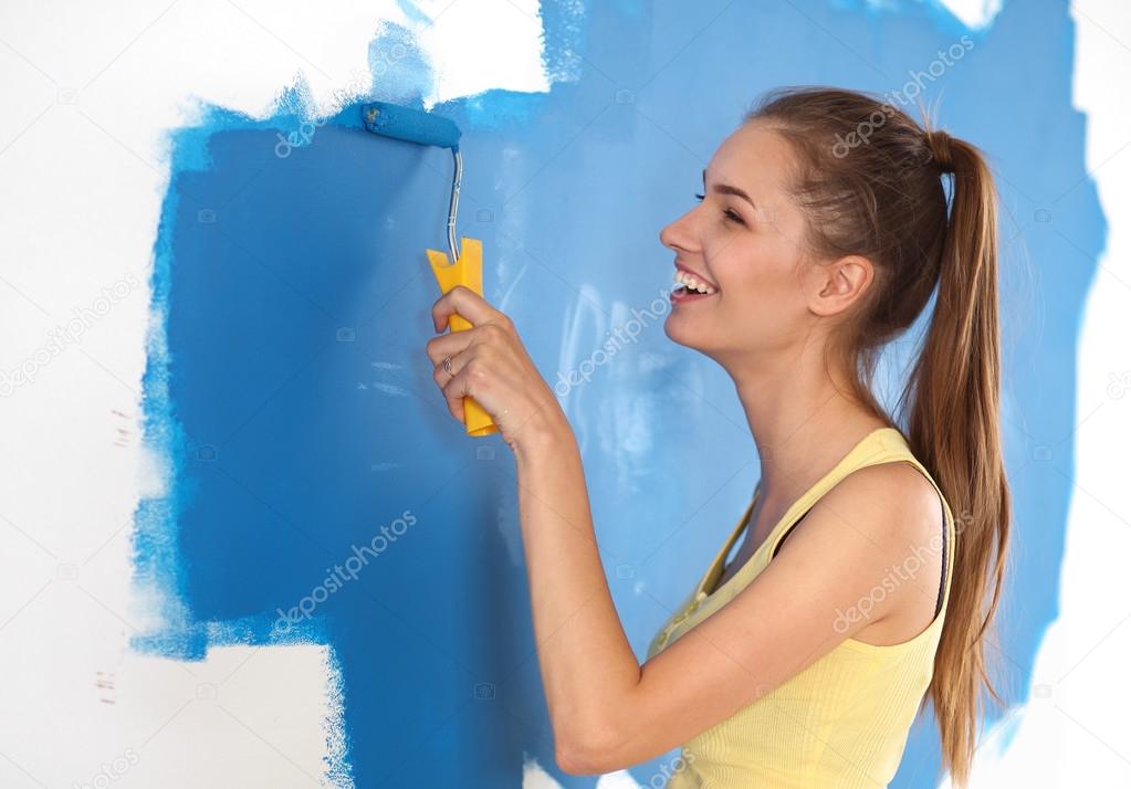 Beautiful young woman doing wall painting