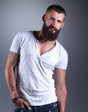 ayakta, gri arka plan üzerinde izole yakışıklı sakallı adam portresi