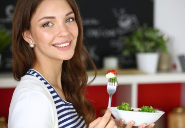 Salata yemek ve karışık salata tutan genç kadın 