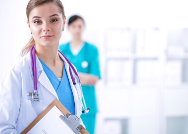 Kadın doktor hastanede dosyayla bekliyor.