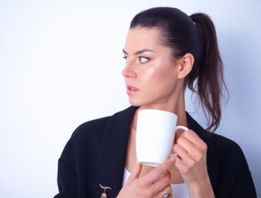 Beyaz arka plan üzerinde izole bir kupa tutan genç kadın