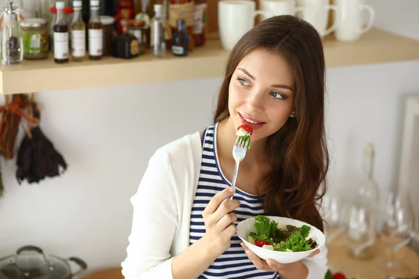 Jonge vrouw salade eten en het bedrijf van een gemengde salade — Stockfoto