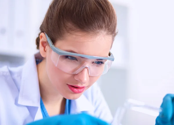 Woman researcher is surrounded by medical vials and flasks, isolated on white background — Stock Photo, Image