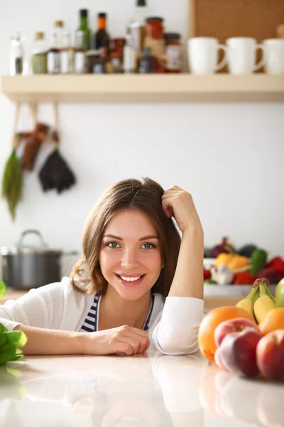 Jonge vrouw in de buurt van bureau in de keuken — Stockfoto