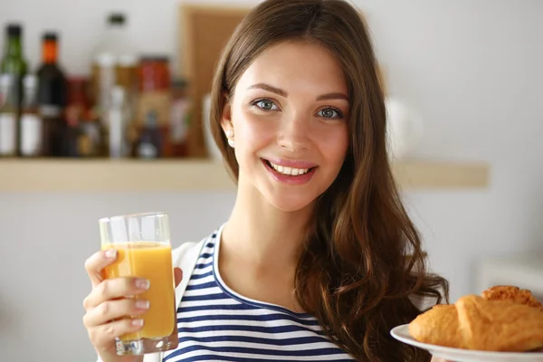 Jeune femme avec un verre de jus et des gâteaux — Photo