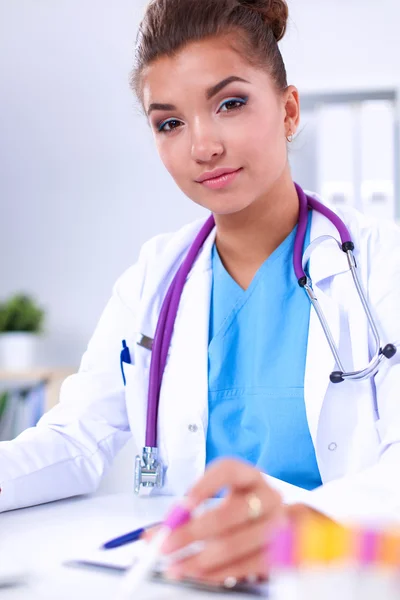 Woman researcher is surrounded by medical vials and flasks, isolated on white background — Stock Photo, Image