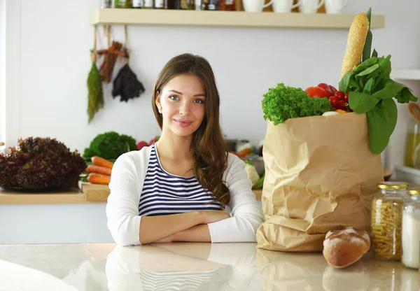 Jonge vrouw zitten in keuken thuis — Stockfoto