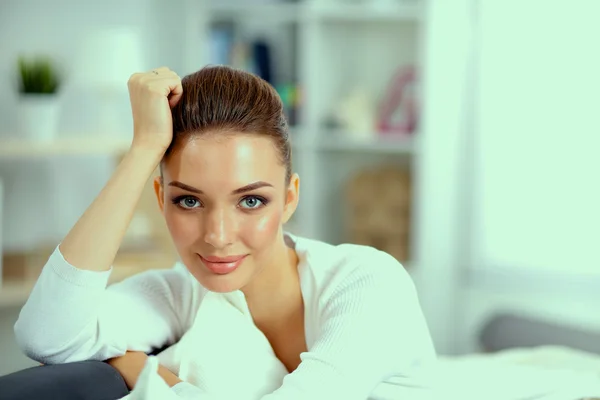 Jonge mooie vrouw zitten op de bank in haar kamer — Stockfoto