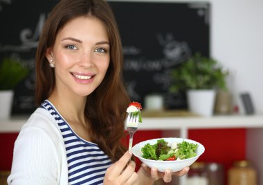 Salata yemek ve karışık salata tutan genç kadın 