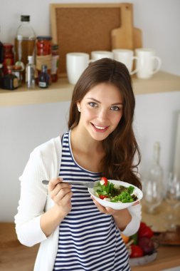 Salata yemek ve karışık salata tutan genç kadın 