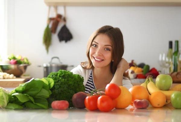 Jonge vrouw in de buurt van bureau in de keuken — Stockfoto