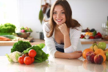 Mutfakta masanın yanında duran genç bir kadın.