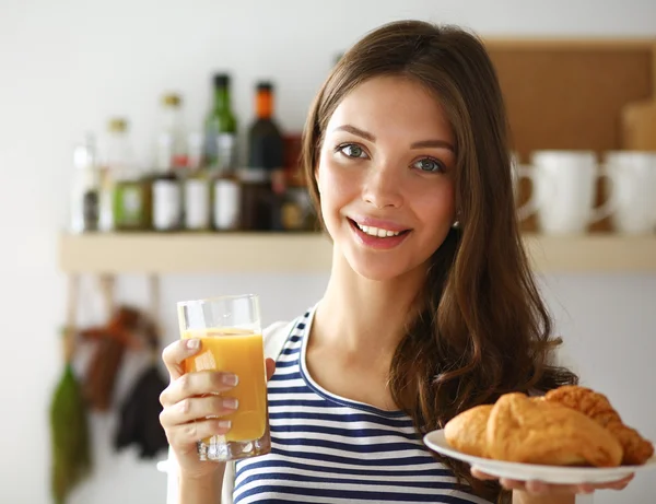 Молодая женщина со стаканом сока и тортами — стоковое фото