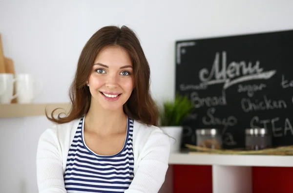 Giovane donna in piedi in cucina a casa — Foto Stock